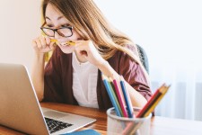 photo of a young woman seated at a laptop computer